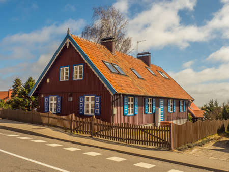 Nida, Lithuania - April 06, 2018: Red wooden house on the headland, National Park Curonian Spit, A nature reserve with forests and a long sandy coast, according to a legend made by a giant.のeditorial素材
