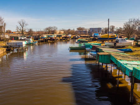 Klaipeda, Lithuania - April 6, 2018: Poor district in the suburbs of the city with houses built on small boats on the bank of the canal, city of slums, shanty town. Eastern Europeの写真素材