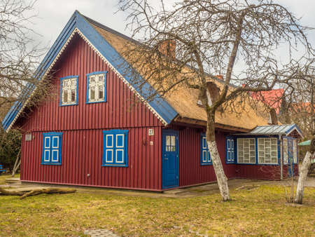 Nida, Lithuania - April 06, 2018: Red wooden house on the headland, National Park Curonian Spit, A nature reserve with forests and a long sandy coast, according to a legend made by a giant.のeditorial素材