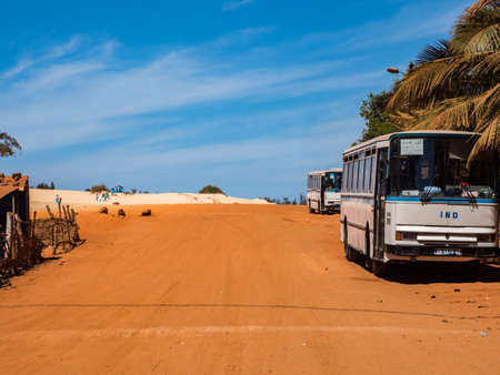 Senegal, Africa - Feb 02, 2019: Old bus the road with red and white sand at the end of the past Paris-Dakar routeのeditorial素材