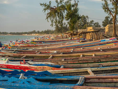 Nianing, Senegal - January 24, 2019: Colorful wooden fisher boats standing on the sandy beach in Senegal. africaのeditorial素材