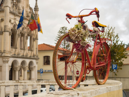 Old, red bike on the fence and a beautiful Town Hall building with the flags of Europe, Portugal and Sintra in the background (CÃ¢mara Municipal de Sintra) Grande Lisboa,のeditorial素材