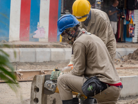 Leticia, Colombia - December 12, 2019: Workers in helmets during the construction of a new road in a small town in the Amazon on the border of the three states of Colombia, Brazil and Peru. Amazonia South America. Tres fronteras area.のeditorial素材