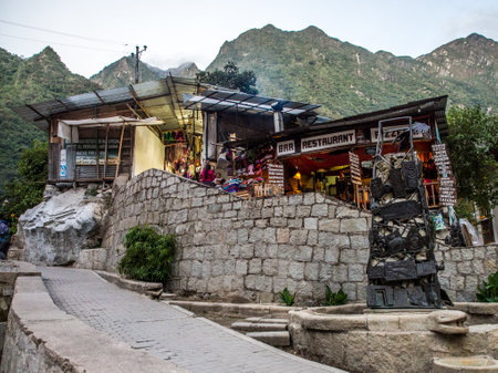 Agua Calientes, Peru - May 21, 2016: Restaurant in Agua Calientes and wodok on the mountain peaks of Machu Picchu hidden high in the mountainsのeditorial素材