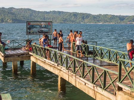Ambon, Indonesia - February 2018: Many children play and swim in the bathing area at the city beach in the coastal town of Ambon. Ambon Island, Maluku Archipelago, (Moluccas) Indonesia. Asiaのeditorial素材