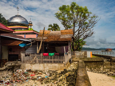 Pasar Kecamatan Pasanea, Indonesia - February 15, 2018: Road and wooden houses in the small village on Seram Island, Central Maluku, Indonesia, Asiaのeditorial素材