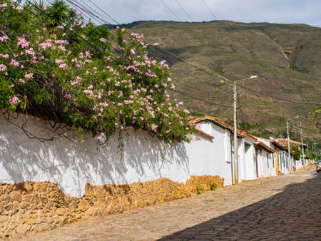 Villa de Leyva, Colombia - May 02, 2016: Cobbled street the in the small town Villa de Leyva with beautiful and unique architecture, beautiful flowers on the fence and view for the mountain, South Americaのeditorial素材