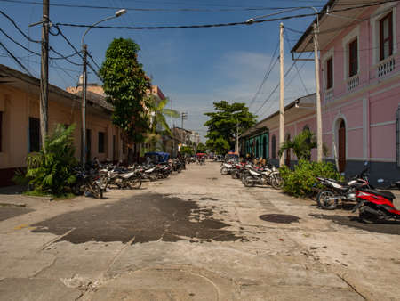 Iquitos, Peru - December 14, 2017: Colonial houses and lots of motorbikes along a street in a small town in the middle of the Amazon jungle in South America. Amazoniaのeditorial素材