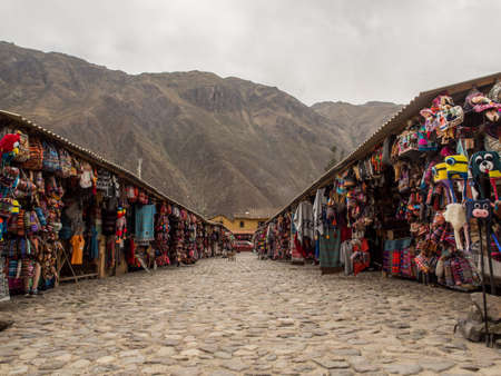 Ollantaytambo, Peru - May 21, 2016: Souvenir market for tourists and view of the Andes in...