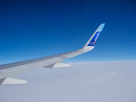 Denmark - Oct 2020: Wing of an Atlantic Airways jet on the background of the blue sky during fly...