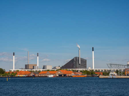 Copenhagen, Denmark - May 31, 2018: Chimneys of a nuclear power plant by the sea. Eco green energy....