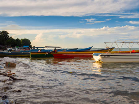 Kaimana, Arguni Bay, Indonesia - February 2018: Colorful wooden boats on the beach at the port of a small town on the Bird's Head Peninsula, West Papua, Asiaのeditorial素材