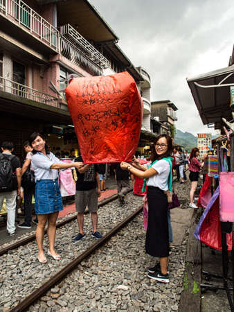 Shifen, Taiwan - October 05, 2016: People with colorful lanterns on the railroad tracks in Shiften