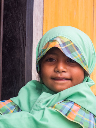 Pasar Kecamatan Pasanea, Indonesia - Feb, 2018: Portrait of a little Muslim girl in traditional dress, Seram Island, Indonesia, Asiaのeditorial素材