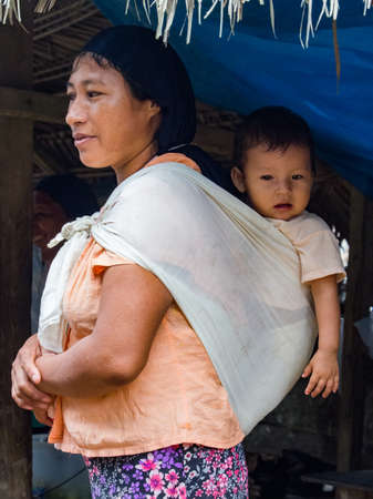 Amazonia, Peru - December 2017: A mother with a small child in a sling in a small village in the middle of the Amazon rainforest on the shore of the Amazon River. Amazon. South Americaのeditorial素材