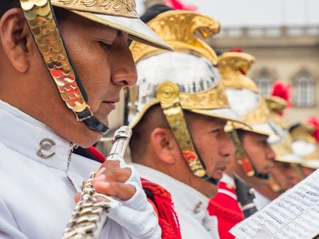 Lima, Peru - December, 2019: Close-up for a man playing the flute. The guards of the Presidential Palace give a concert in the Plaza de Armas before the ceremony changes. South Americaのeditorial素材
