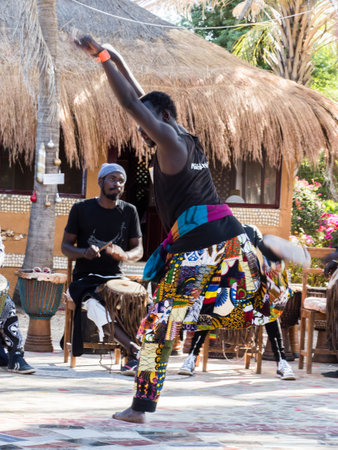 Senegal, Africa - January 24, 2019: African man dances African dances to African music played on drumsのeditorial素材