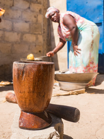 Senegal, Africa - Jan, 2019: Senegalese woman in a traditional costume called 'boubou' cooking the meal in the african home.のeditorial素材