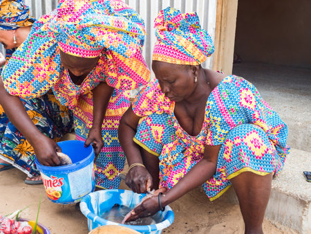 Senegal, Africa - Jan, 2019: Senegalese woman in a traditional costume called 'boubou' cooking the...