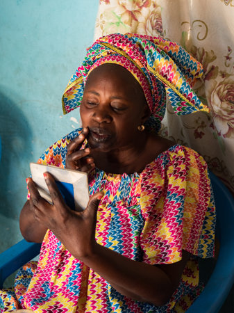Senegal, Africa - January 2019: Portrait of a beautiful Senegalese woman in traditional dress called boubou doing typical African makeupのeditorial素材