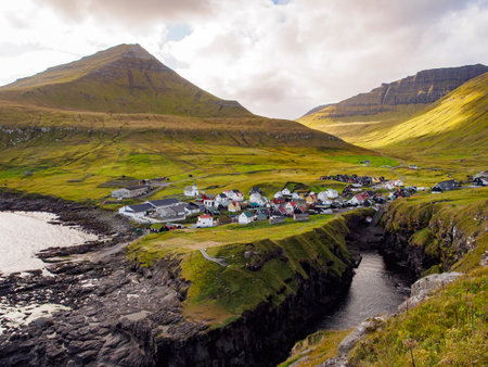 GjÃ³gv, Faroe Islands - Sep, 2020: Natural harbor gorge nearby idyllic village Gjogv. Eysturoy Island on the Faroe Archipelago. It is an autonomous territory within the Kingdom of Denmark. Europe.のeditorial素材