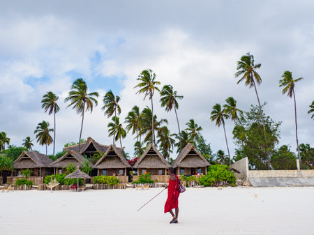 Zanzibar, Tanzania - January 2021: African Maasai warriors in traditional dress on a sandy beach. Africaのeditorial素材