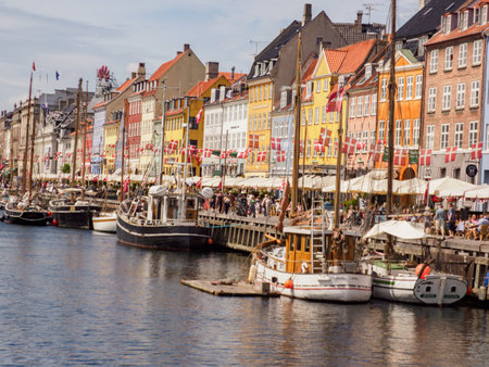 New Harbour, Copenhagen, Denmark - July 2021: View of Nyhavn canal with plenty of flags on the background of color buildings in the Old Town of Copenhagen. Europeのeditorial素材