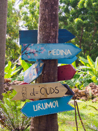 Kizimkazi, Tanzania - January 2021: Signposts on colorful wooden plates of an African village on the tropical island of Zanzibar. Assalam Community Foundation, Africa.のeditorial素材