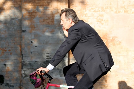 Business man in Rome using bicycle and phoneのeditorial素材