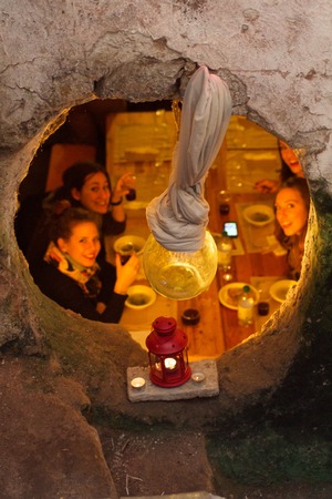 Rome, November 2013, view by an hole in a wall of beautiful girls have dinner in very old restaurantのeditorial素材