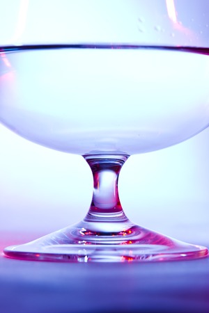 glass for brandy  on blue and red backgroundの写真素材
