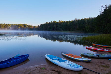 Kayaks on the shore of the lake in the early morning.