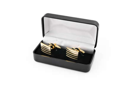 Golden cuff links in a black box; isolated on white
