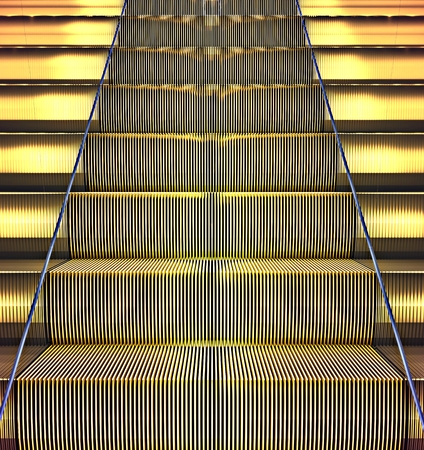 Front view on a golden escalatorの写真素材