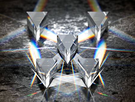 Close-up on prisms refracting light and producing chromatic dispersions, on black glossy concrete