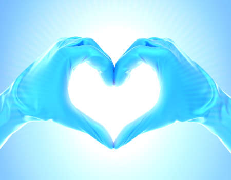 Doctor's hands with gloves forming a heart with shiny light on the centerの写真素材