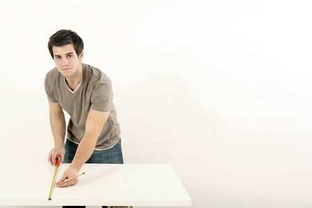 Man using tape measure on wooden boardの写真素材