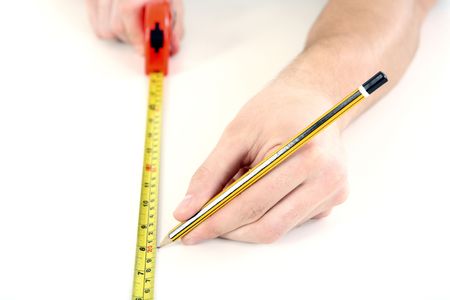 Man using tape measure on wooden boardの写真素材