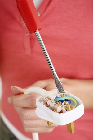 Woman fixing an electric plugの写真素材