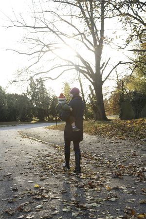 Mother carrying son while strolling in the parkの写真素材