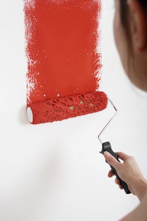 Woman painting wall with paint rollerの写真素材