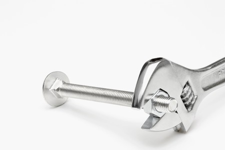 Crescent wrench tightening nut into boltの写真素材