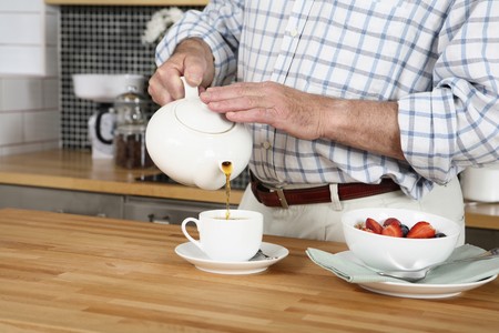 Senior man pouring tea into cupの写真素材