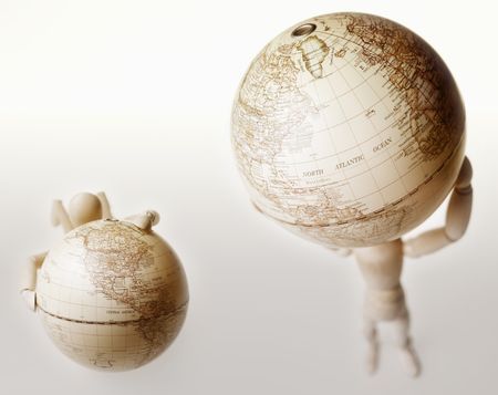 Dummy lifting globe while another dummy with hands on globe
