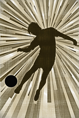 Silhouette of a footballer kicking a ballの写真素材