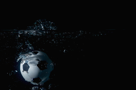 Soccer ball splashing into waterの写真素材