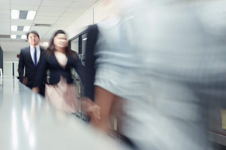 Blur motion of businessman and businesswoman walkingの写真素材