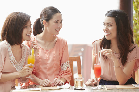 Young women having a drink togetherの写真素材