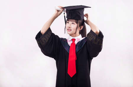 A girl wearing a bachelor's suit on a solid background