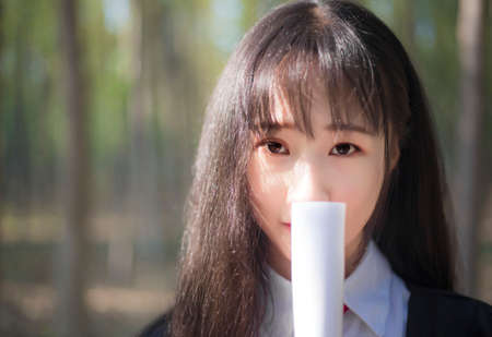 A girl in a bachelor's suit in the woodsの写真素材